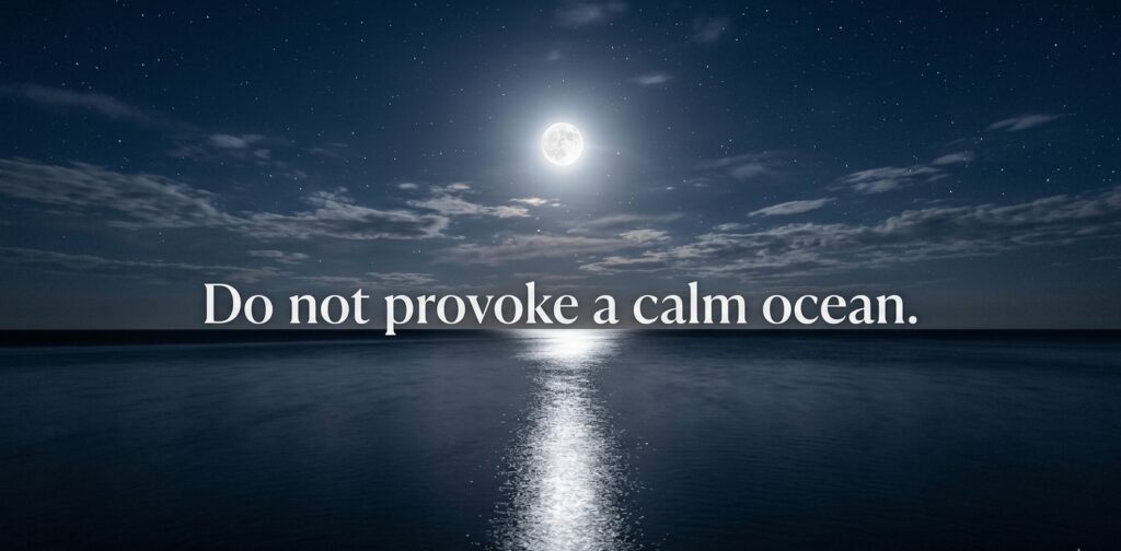 A wide-angle landscape photograph of a calm ocean surface reflecting the light of a prominent full moon in a clear starry night sky. White text over the image reads: Do not provoke a calm ocean.